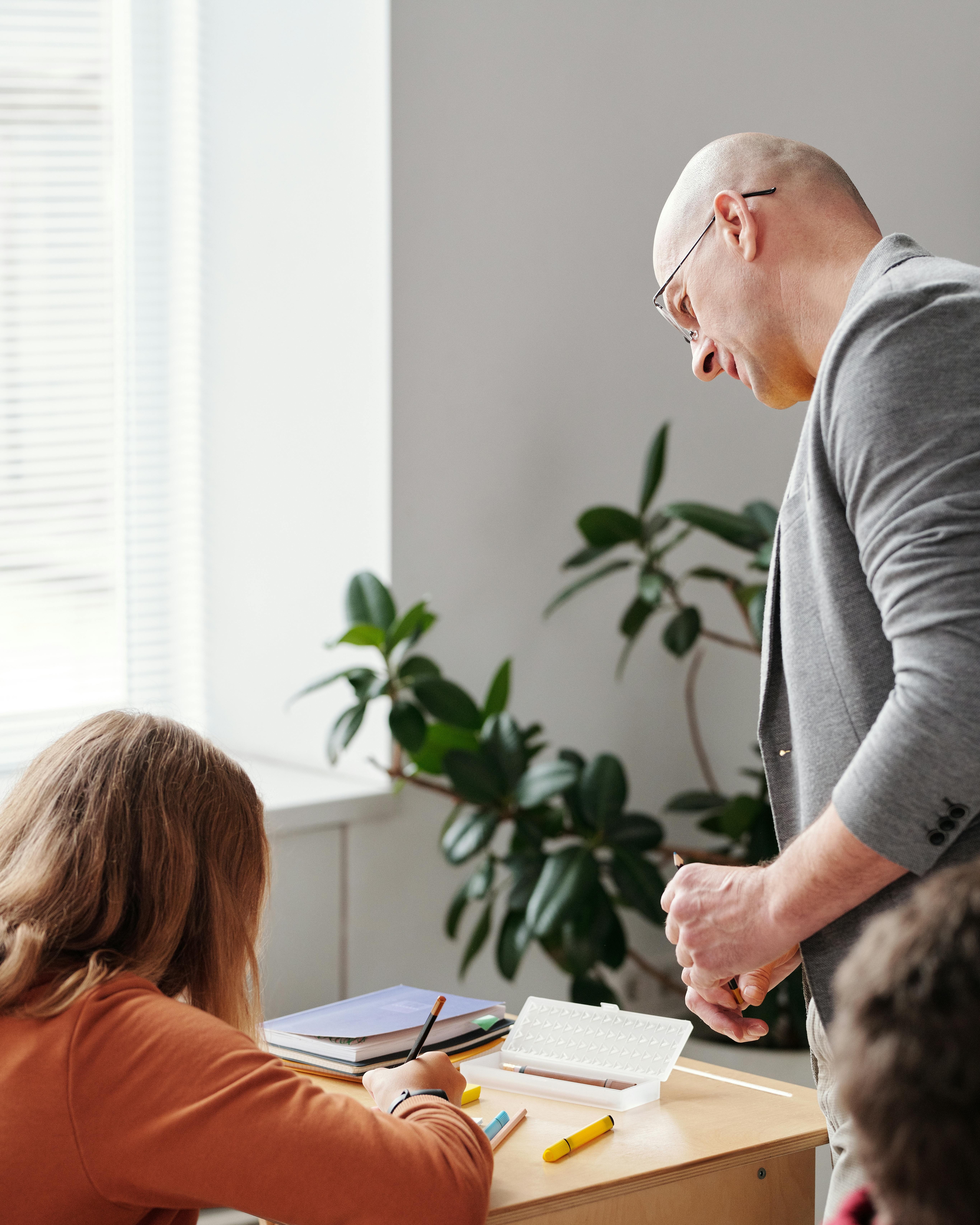 Teacher helping a student at their desk
